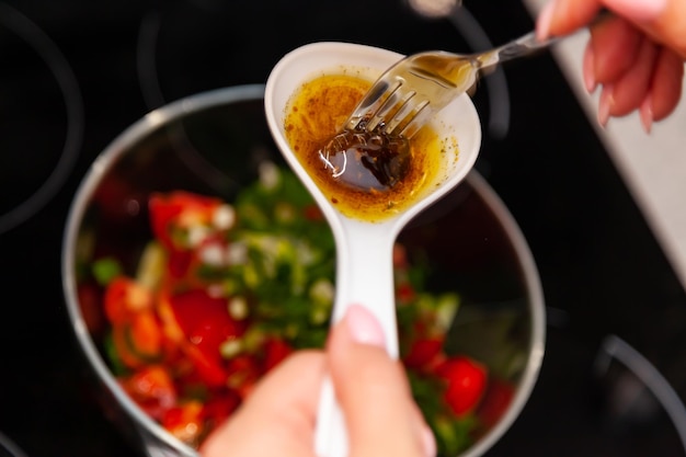 Bliska ujęcie gotującej ręki mieszającej sos